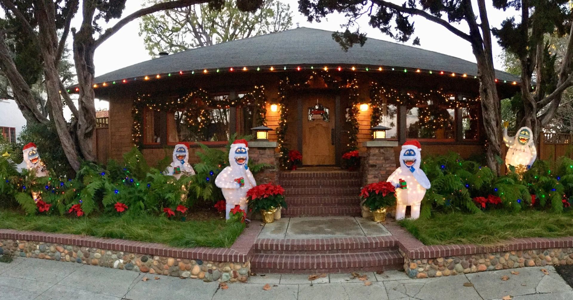 Craftsman home with lights, garland and whimsical snowman figures